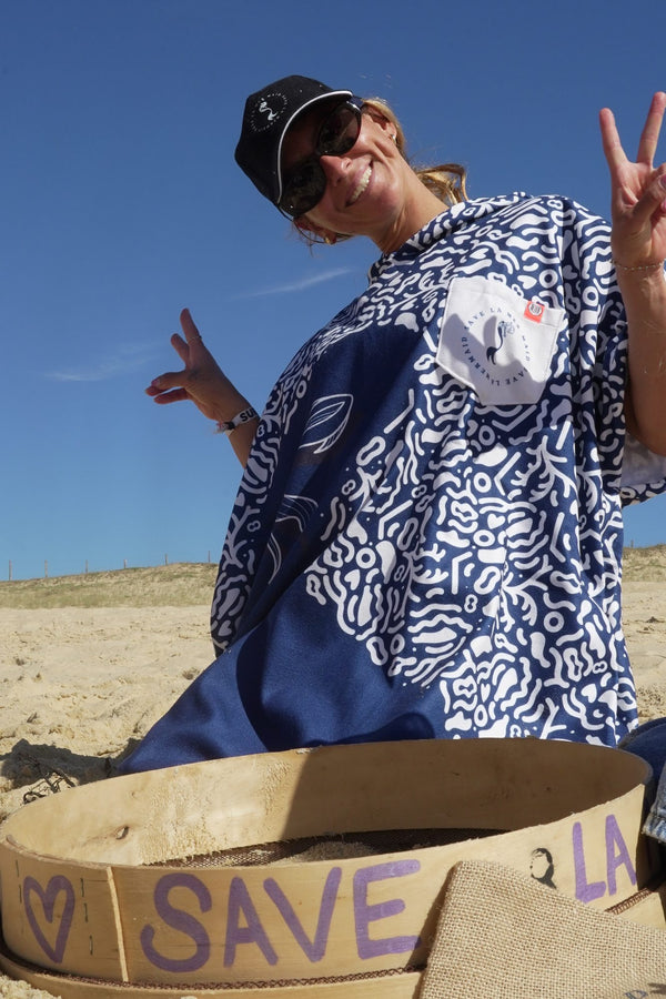Maud Le Car im Save La Mermaid-Poncho am Strand