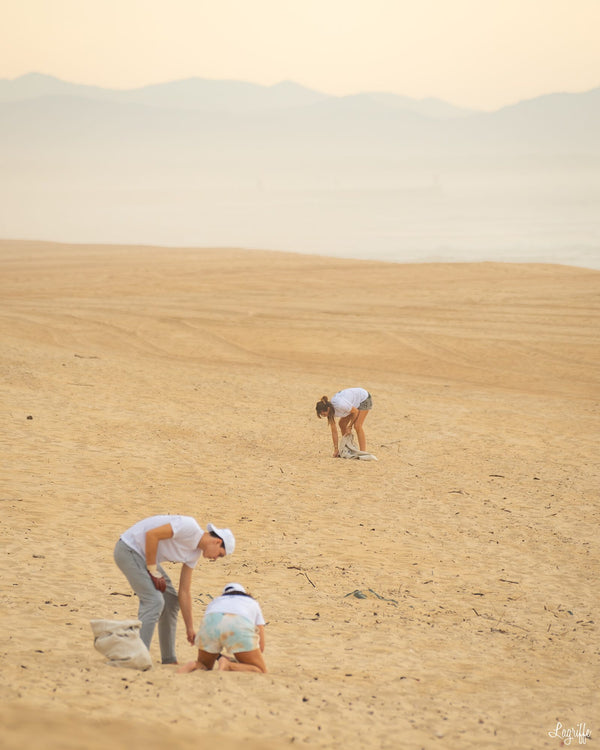 Freiwillige, die an einem riesigen Strand Müll aufsammeln