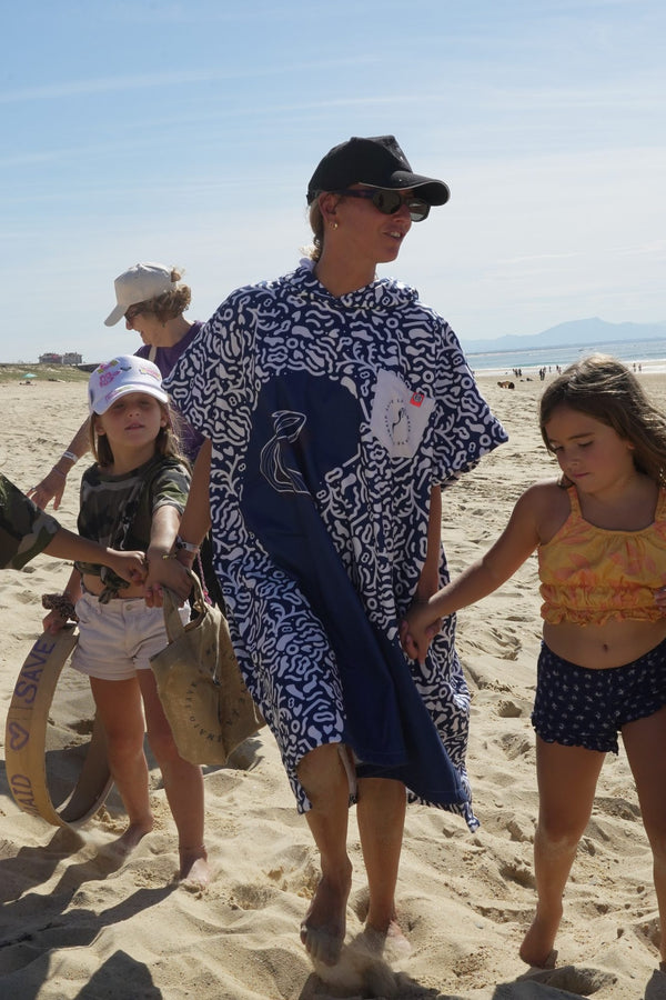 Poncho Save La Mermaid, getragen bei einem Strandspaziergang